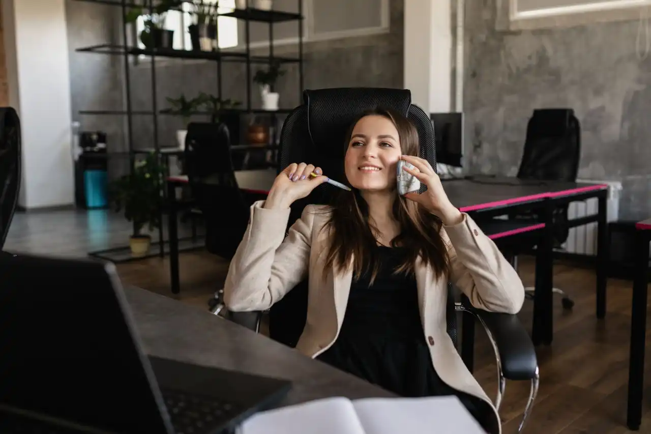 Una mujer sonriendo mientras habla por teléfono