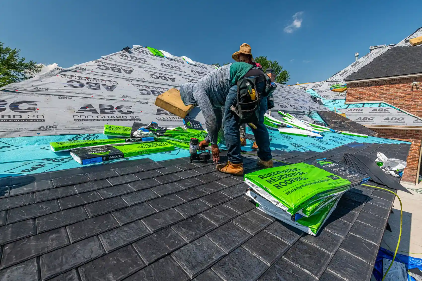 A roofer laying underlayment on a new roof